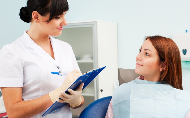 A doctor talking to a patient and writing